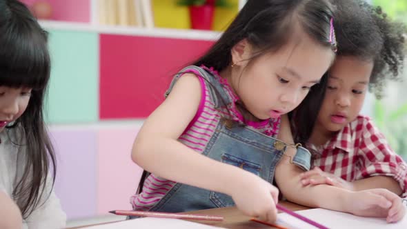 Group of children drawing in classroom, Multi-ethnic young boys and girls happy funny study.