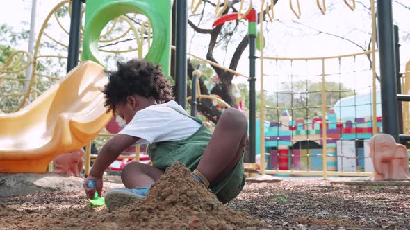 African American child having fun playing with sand in playground