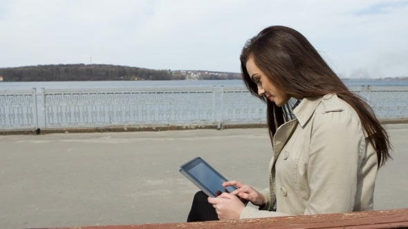 Young Woman With Tablet On The Bench