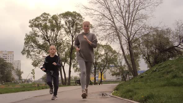  Mother and Daughter Running Joggin Outdoor in the Park