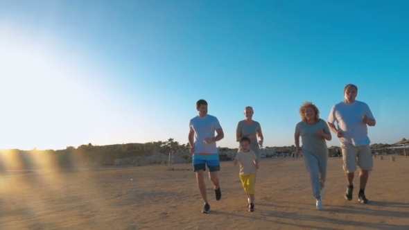 Family Jogging On The Beach