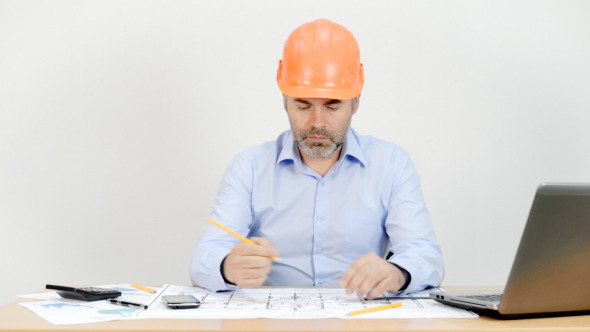 Engineer Working in Office on Blueprint