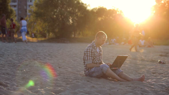 Resting Man at Sunset with a Laptop