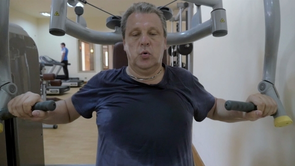 Sweaty Man Working Out On Exercise Machine