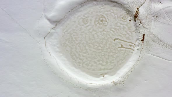 Aerial top down rotation of Lake Ram or Birkat Ram in snow on Mount Hermon, Israel, The mountain and