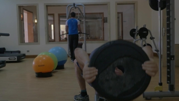 Two Men Training Using Sporting Equipment In Gym