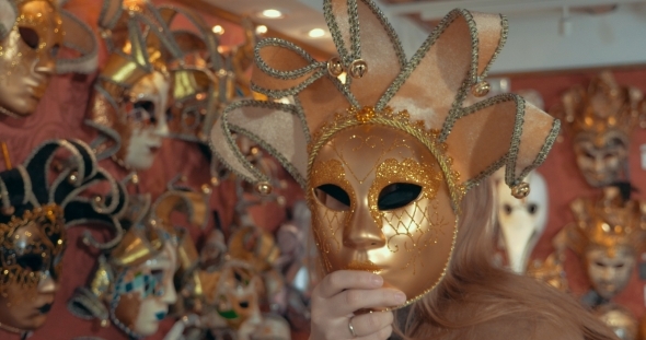 Woman In The Store Trying On Golden Venetian Mask
