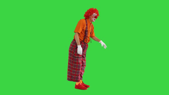 Actor Dressed As a Clown Looking for a Way To Act in a Funny Way on a Green Screen Chroma Key