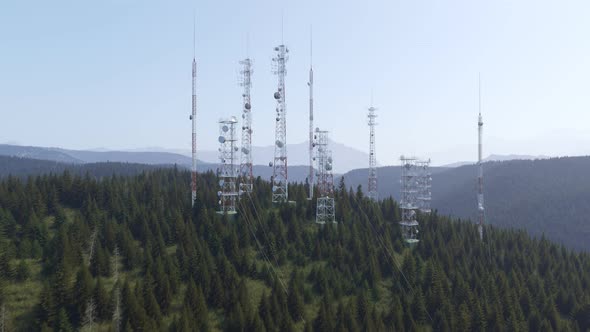Antennas complex on a forested hill. Radio masts and towers for broadcasting.