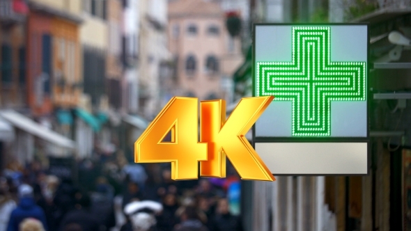 Pharmacy Sign With Green Cross In Busy Street