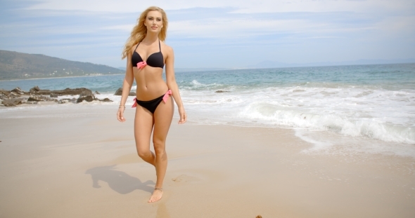 Blond Woman In Black Bikini Walking On Beach