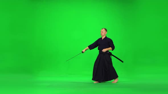 Masculine Kendo Warrior Practicing Martial Art with the Bamboo Bokken on Green Screen.