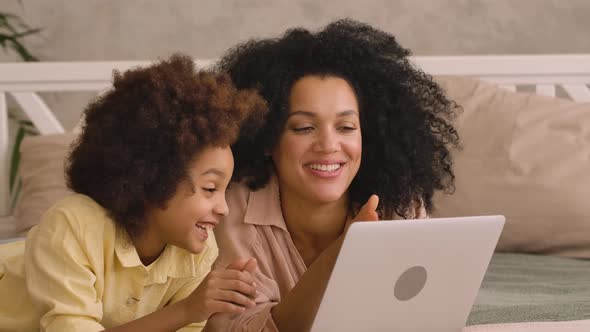 African American Woman and Litle Girl Talking on Video Call Using Laptop