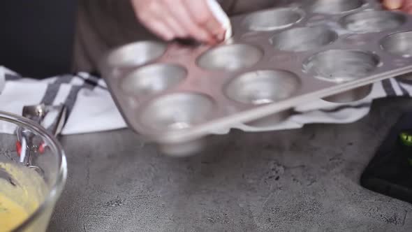 Step by step. Greasing muffin pan for baking spicy jalapeno cornbread muffins.