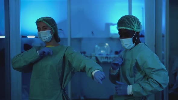 Doctors wearing personal protective equipment having fun dancing in laboratory