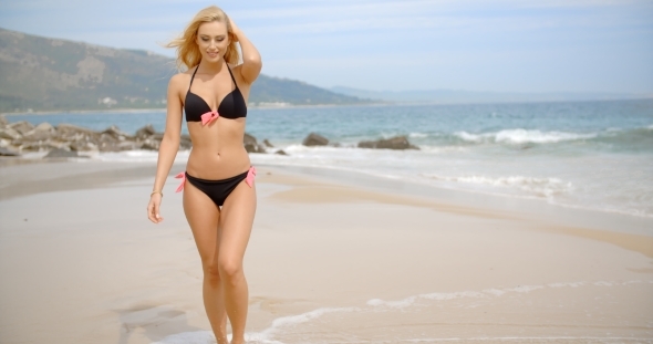 Blond Woman Wearing Black Bikini Posing On Beach