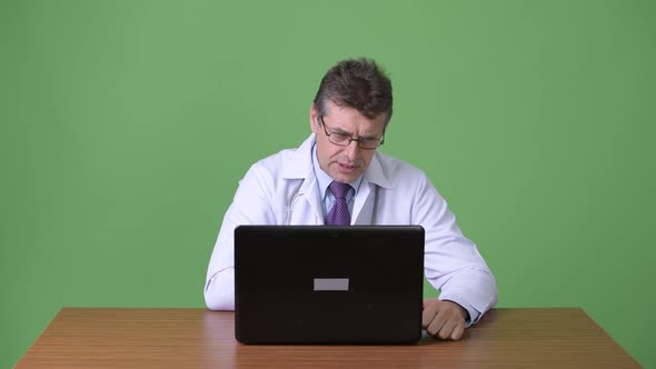 Mature Handsome Man Doctor Against Green Background