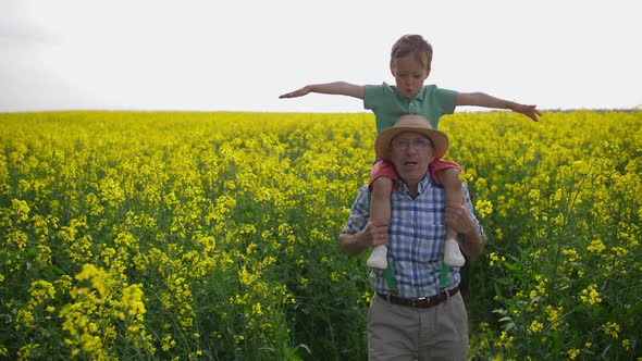 Grandfather and Grandson During Walk Through Field