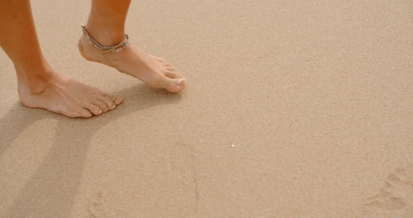 Bare Feet Coated In Sand Walking On Beach