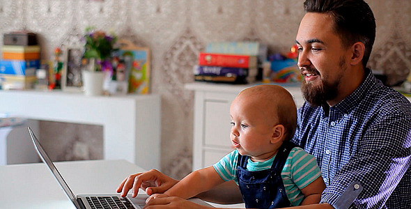 Young Father with a Child Working on a Computer