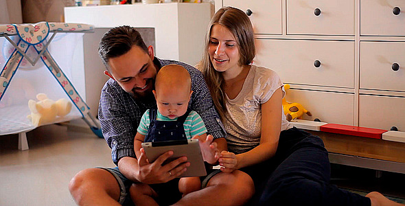Young Parents with a Baby Watching in the Tablet