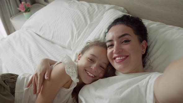 Portrait Happy Cute Funny Cheerful Mom and Daughter Gently Hugging Daughter with Mom Take Selfie