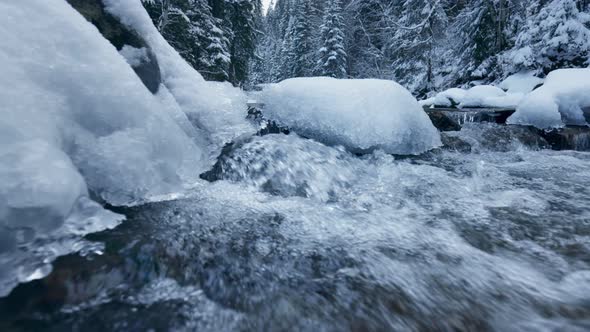 Fast River with Crystal Water Flows Through the Winter Forest