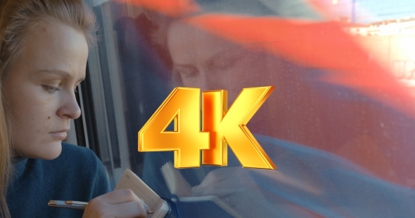 Woman Taking Notes Or Drawing In Train alt