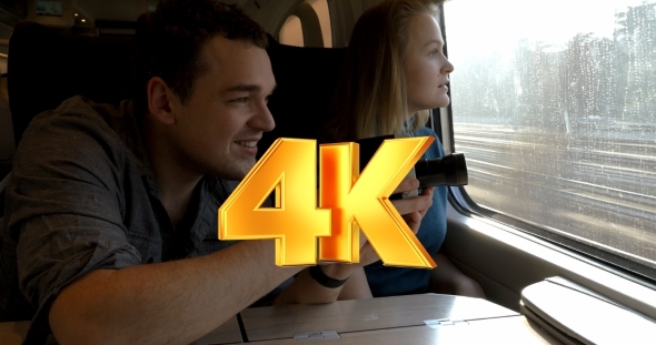 Young Couple With Retro Video Camera In Train alt