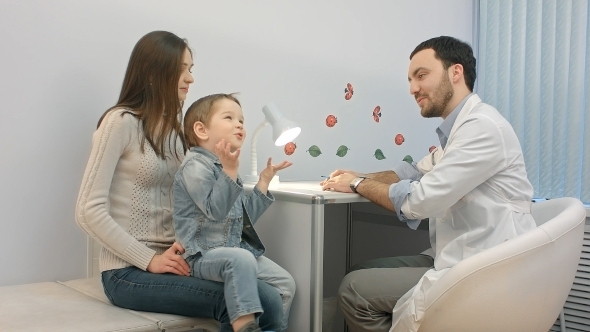 Doctor Talking To Young Child And Mother
