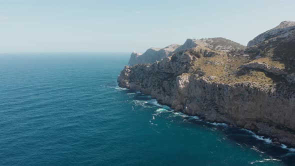 Picturesque Landscape Of Rocky Limestone Cliffs At Cala Figuera Surrounded By The Calm Blue Sea In S