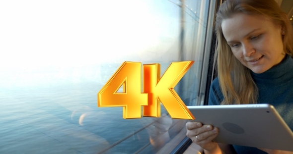 Woman Traveling By Train And Using Tablet PC alt