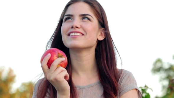 Portrait Of Smiling Beautiful Girl With An Apple alt