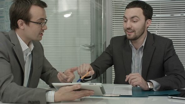Image Of Two Young Businessmen Using Touchpad