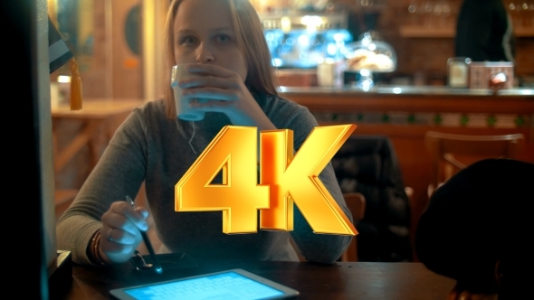 Woman Using Tablet PC With Stylus In Cafe alt