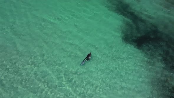 Aerial drone View Of A Free Diver Swimming On The Tropical Beach In Carnarvon, West Australia - Aeri