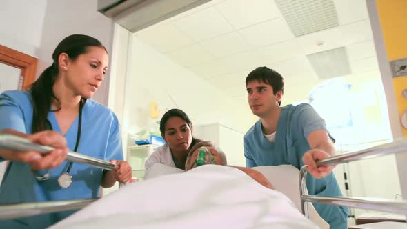 Nurses wheeling a patient on his bed with an oxygen mask