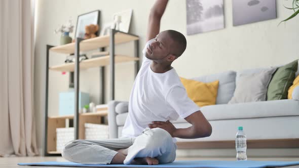 Young African Man Doing Yoga on Yoga Mat at Home