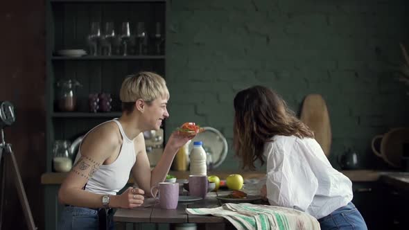 Woman Two Friends Eating Sandwich in Kitchen