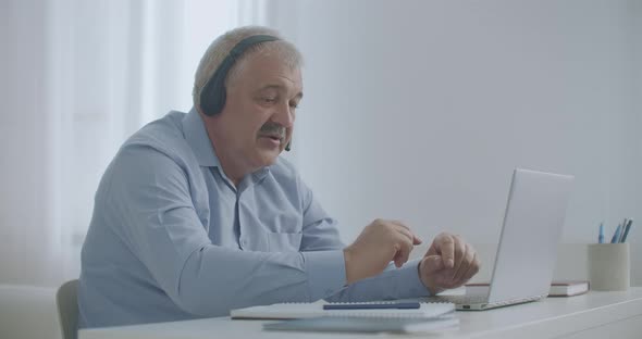 Middle-aged Man Is Talking By Video Chat with Colleagues, Working Remotely, Connecting with