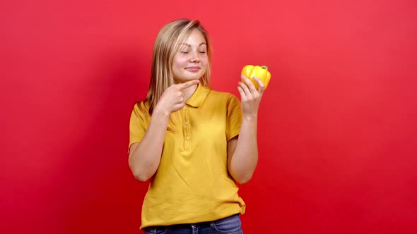 Cute and Slightly Fat Girl in a Yellow T-shirt Who Holds the Yellow Pepper in Her Hand