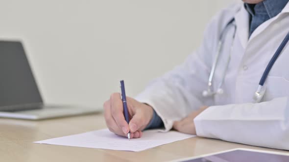 Close Up of Doctor Writing on Paper 