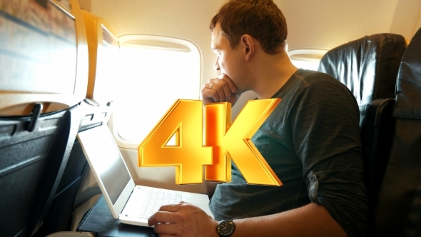 Young Man Chatting On Laptop In The Plane alt