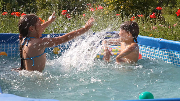 Kids Have Fun Swimming in a Pool 