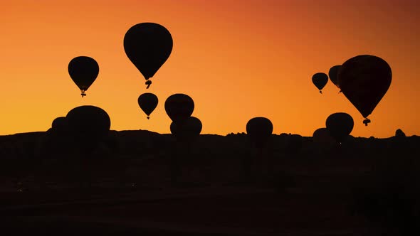 Silhouettes of Hot Air Balloons on Orange Sunset Sky Background.