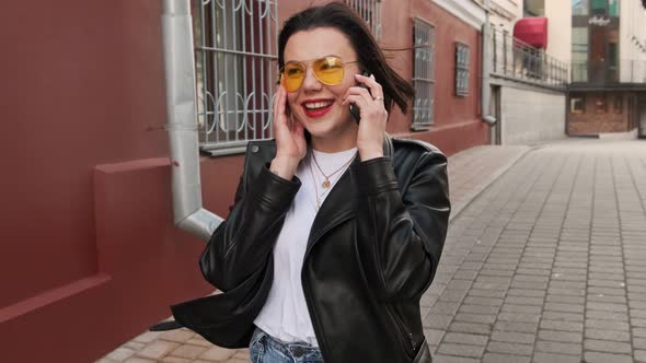 Young woman walking in the street she talking nicely on the phone 