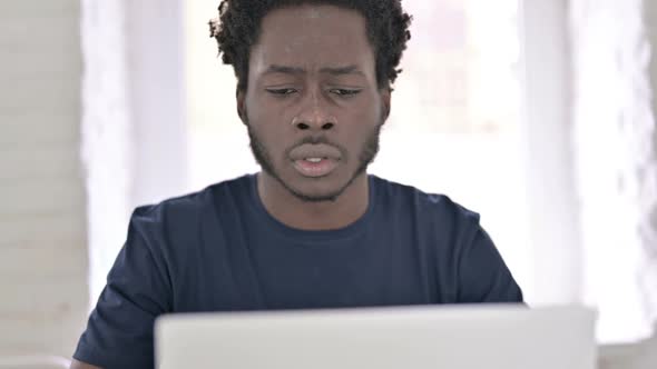 Close Up of African Man Having Shock for Loss on Laptop