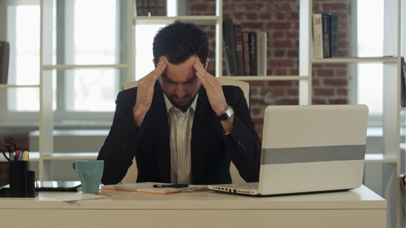 Depressed Businessman Sitting At Computer