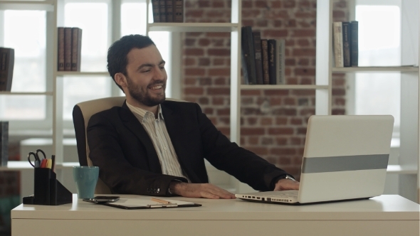 Smiling Man With a Laptop In Office