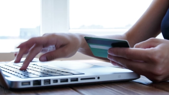 Paying With Credit Card Online On Wooden Desk